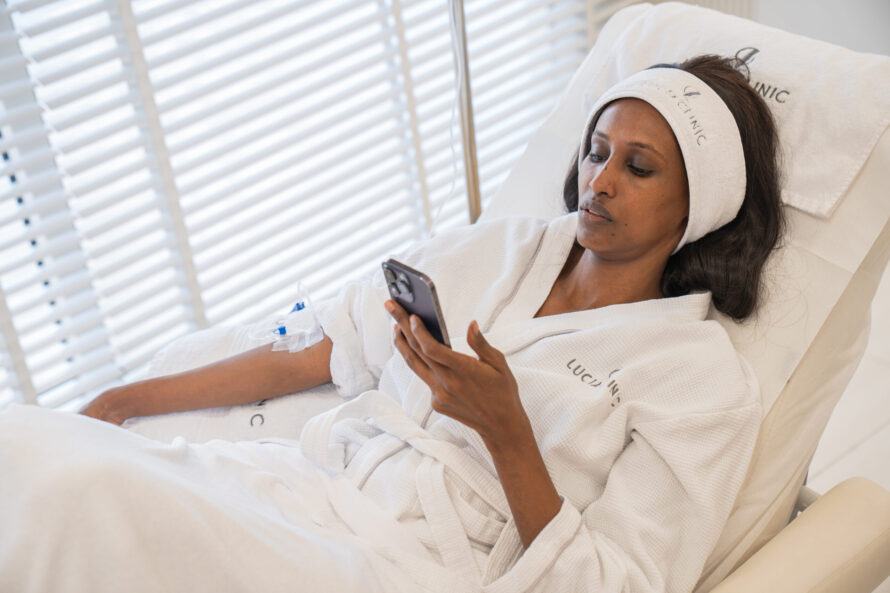 A woman using her phone while getting therapy
