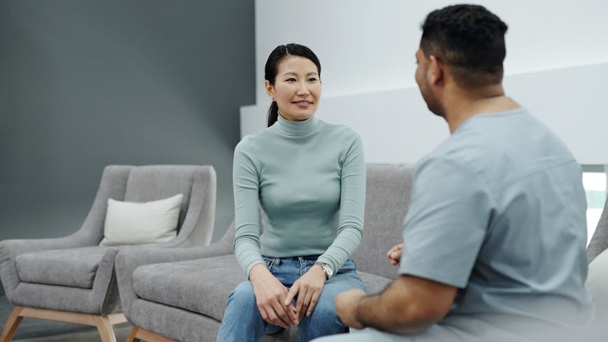 A woman talking to her doctor about how to fix uneven breast implants