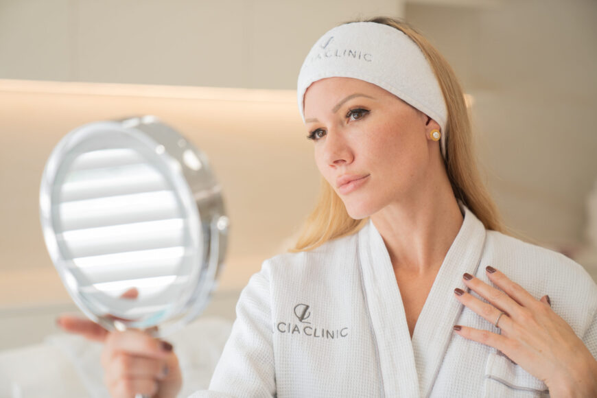 A woman looking at the mirror after the complete rhinoplasty recovery