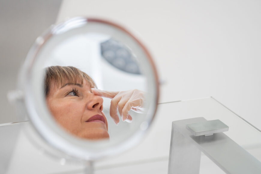 A woman looking at her nose in a mirror