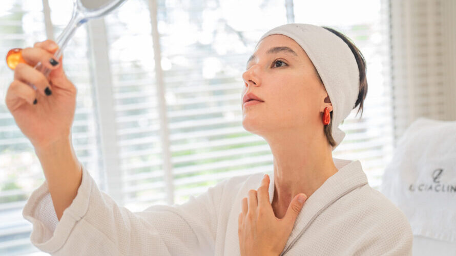 A woman looking at a mirror after cosmetic surgery