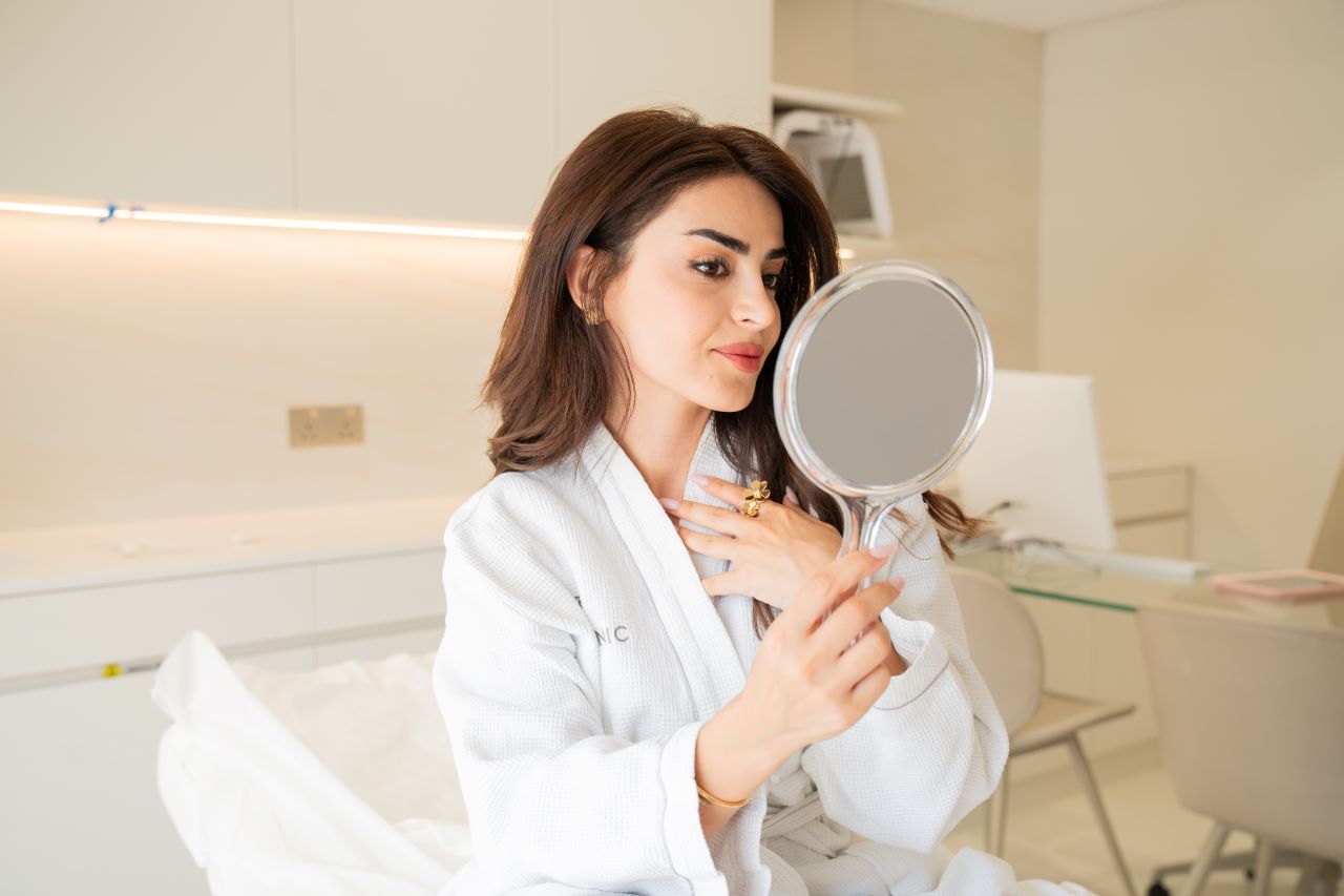 A woman looking her face in a mirror