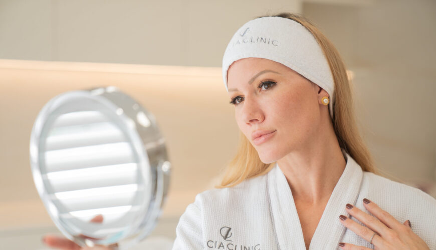 A woman looking at her hands in a mirror