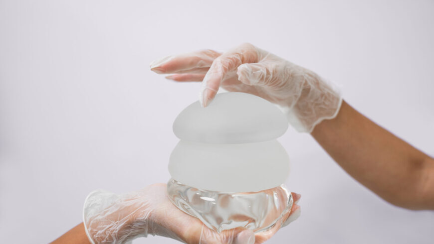 Hands holding different breat implants