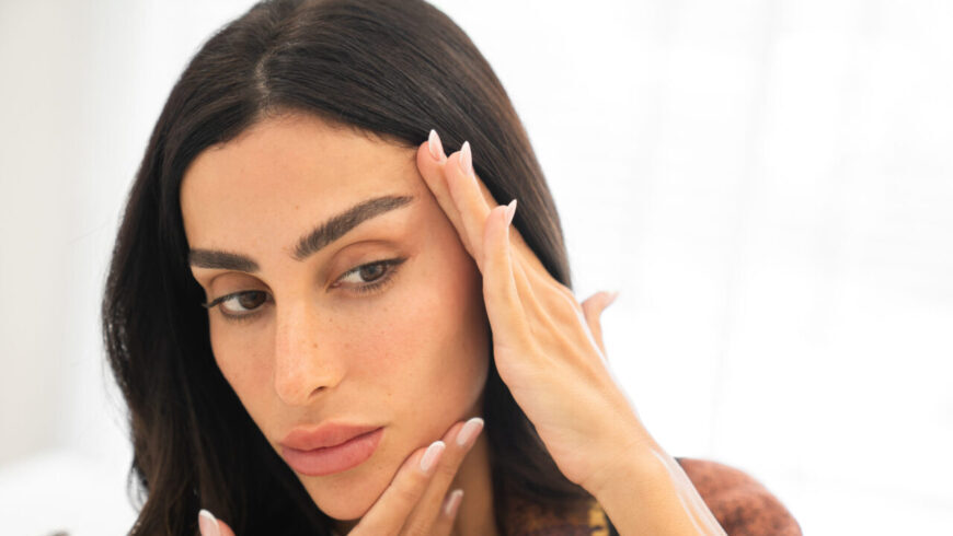 A woman looking at her face